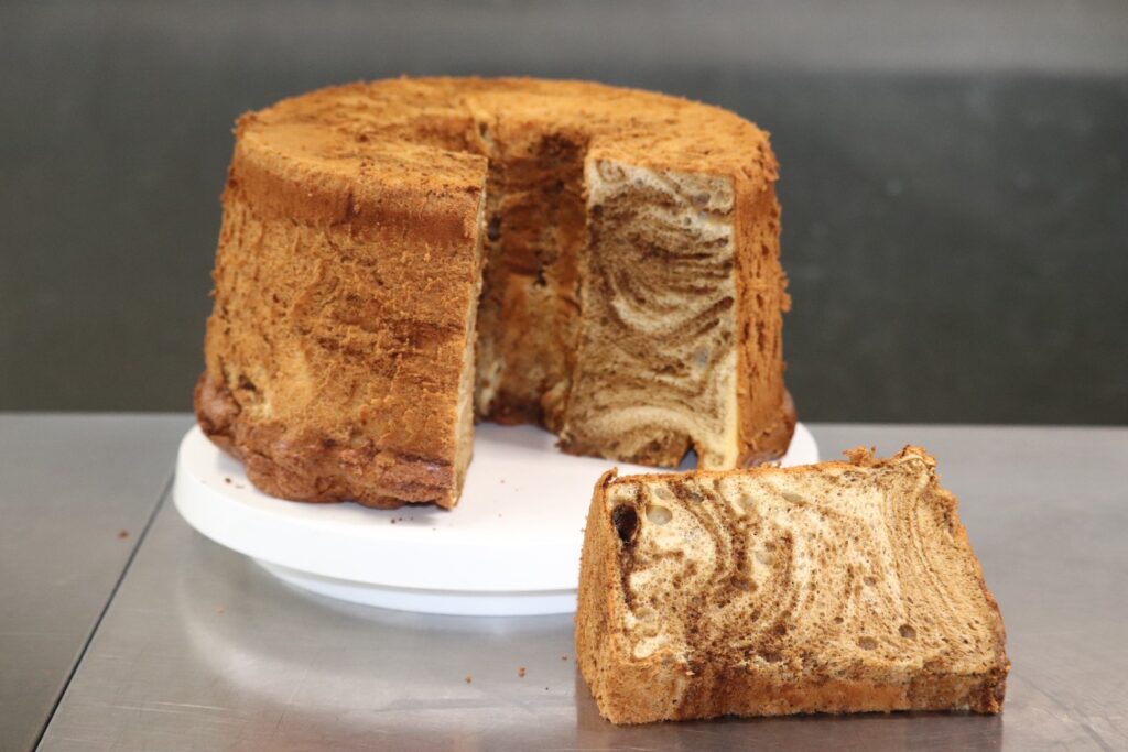 Alt属性: 職人が焼き上げた断面の美しいコーヒーマーブルシフォンケーキ。しっとりふわふわの食感。
